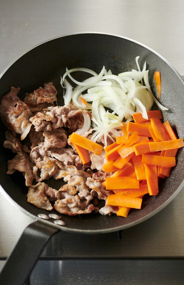野菜も入れてからしばらくはいじらない。30秒ほどで上下を返す。1分焼いたら、先に玉ねぎとにんじんを合わせ、次に豚肉を少しずつ合わせて、全体を肉から出た脂に絡ませていく。