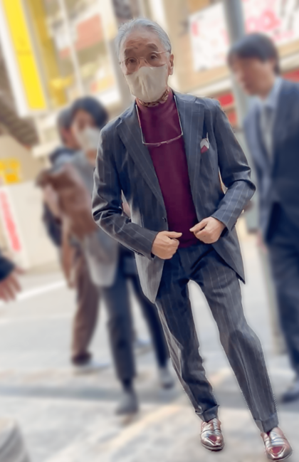 グレーのストライプスーツを着こなして会場に入っていく堺。