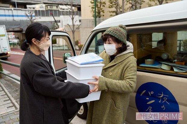 夜のパン屋さんのために手作りしたマフィンを枝元さんに渡す、チームむかごの柳澤さん　撮影／伊藤和幸