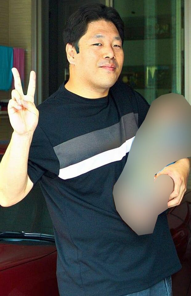 子どもを片手で抱っこし、右手でピースする西岡容疑者（本人のフェイスブックより、一部加工）