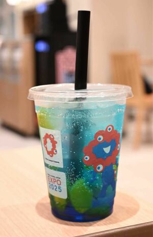 物議を醸したエスタシオンカフェの『ミャクミャクフルーツソーダ』。本来は真っ赤なチェリーが浮かんでいるはずが……。（Xより）