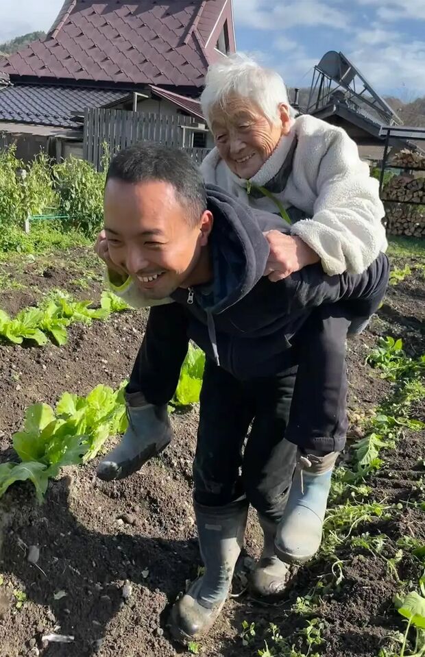 利用者をおんぶする稲葉さん。日課はお年寄りと“楽しいこと探し”をすることだと話す