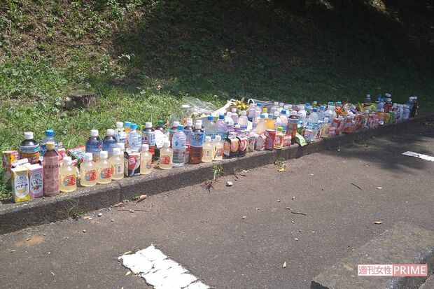 事件現場の駐車場には多くの飲み物などが供えられている
