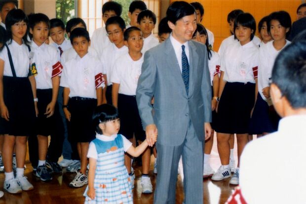 天皇陛下（当時は皇太子）に手を引かれ、沖縄の子どもたちと交流される2歳の愛子さま（2004年）