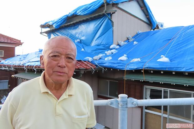 リーダーシップを発揮する嶋田政雄さん。被災した自宅前で＝館山市