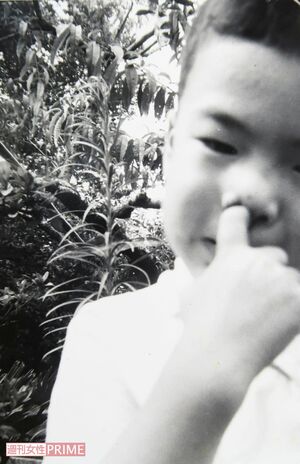 鼻の穴に指を突っ込んでおどける容疑者。幼少期は快活なところもあったよう（兄提供）