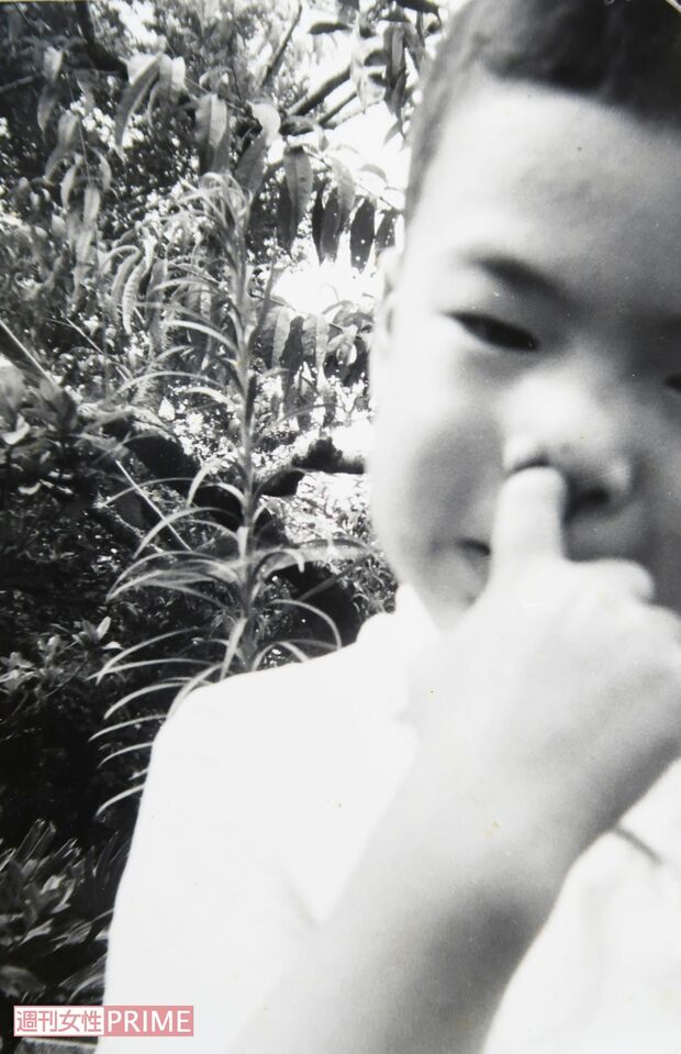 鼻の穴に指を突っ込んでおどける容疑者。幼少期は快活なところもあったよう（兄提供）