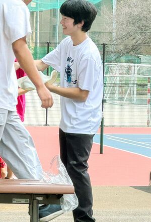 筑波大学附属高校の文化祭で、ご学友とピザ生地のようなものをくるくると回す悠仁さま（来場者提供）