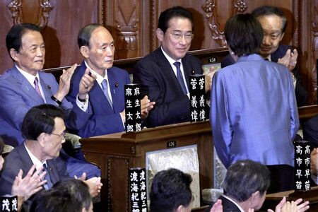 2025年10月21日、女性初の内閣総理大臣に任命された高市早苗。自民党の(奥左から)麻生太郎副総裁、菅義偉元首相、岸田文雄元首相らに向け頭を下げた(撮影/共同通信)