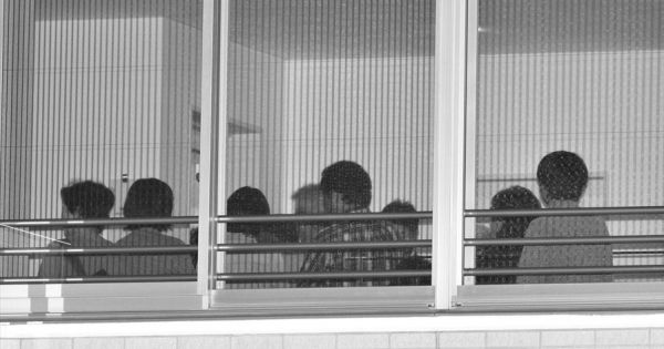  15日夜、マンション内の集会室で開かれた説明会には、不安げな表情の住民たちが