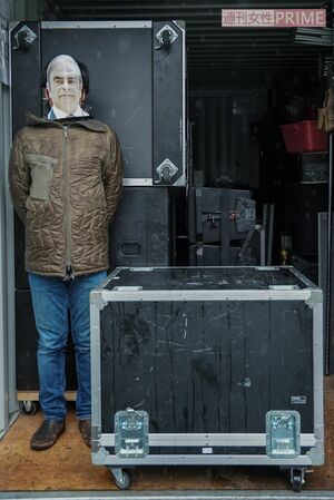 ゴーン被告のお面をかぶった記者と箱の対比。箱の高さ、幅は身を屈めないと窮屈