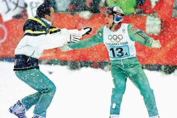 1998年長野・日の丸飛行隊（スキージャンプ）（原田雅彦、船木和喜、岡部孝信、斎藤浩哉）個人ラージヒルで金と銅に輝いた船木和喜と原田雅彦。中でも原田の大ジャンプはアナウンサーの「立て、立て、立ってくれー」という名実況を生んだ。迎えた団体戦、1本目で4位と出遅れた日本チーム。猛吹雪で中断後の2本目、岡部と原田が137mの大ジャンプで首位に。最後に飛んだ船木に、メンバー3人が抱き着いて喜びを分かち合った　写真/アフロ