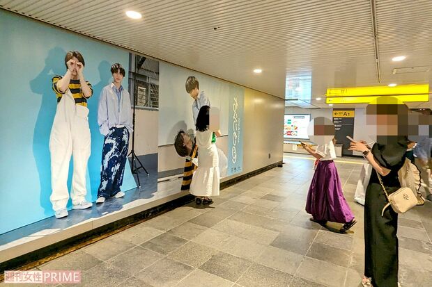 渋谷駅地下通路に展示されたKing&Prince『なにもの』巨大広告と記念撮影をするファン