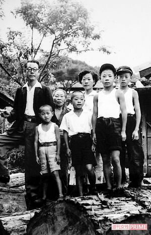 実家の製材所で、両親、祖母、男兄弟と。いちばん小さいランニングの少年が外波山