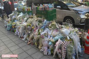 火災があったビル前に多くの献花(12月21日撮影)