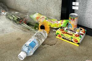 現場アパートには花や子どもの好きそうなジュース、チョコ菓子などが供えられて