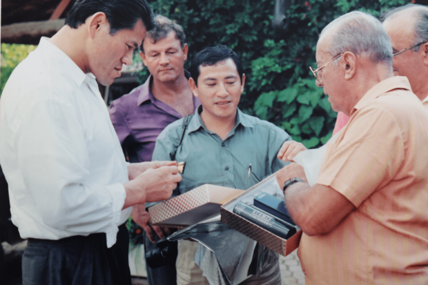 80年代。当時のブラジル大統領、ジョアン・フィゲイレド氏（右）の説明を聞くアントニオ猪木氏（左）と通訳する啓介さん