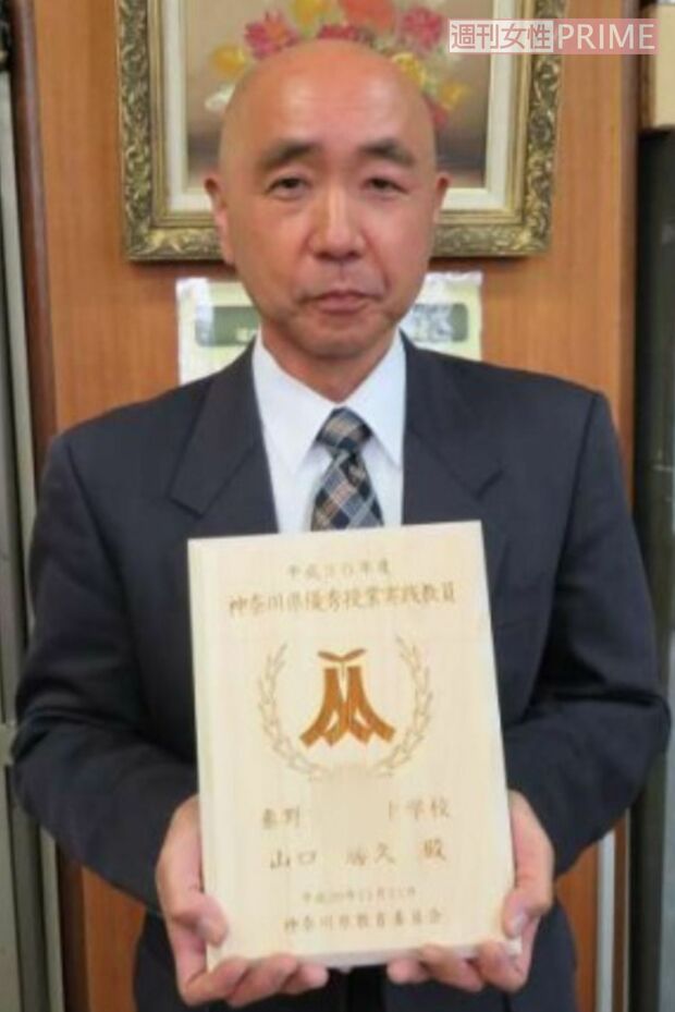 「優秀教師」の表彰状を持つ山口容疑者（勤務先だった中学校の資料より）