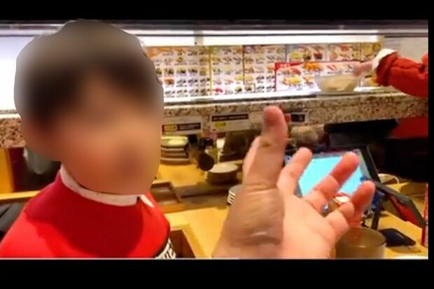 ネットで拡散されている、回転寿司店でレーンに流れる商品を触る次男の動画（一部、編集部加工）